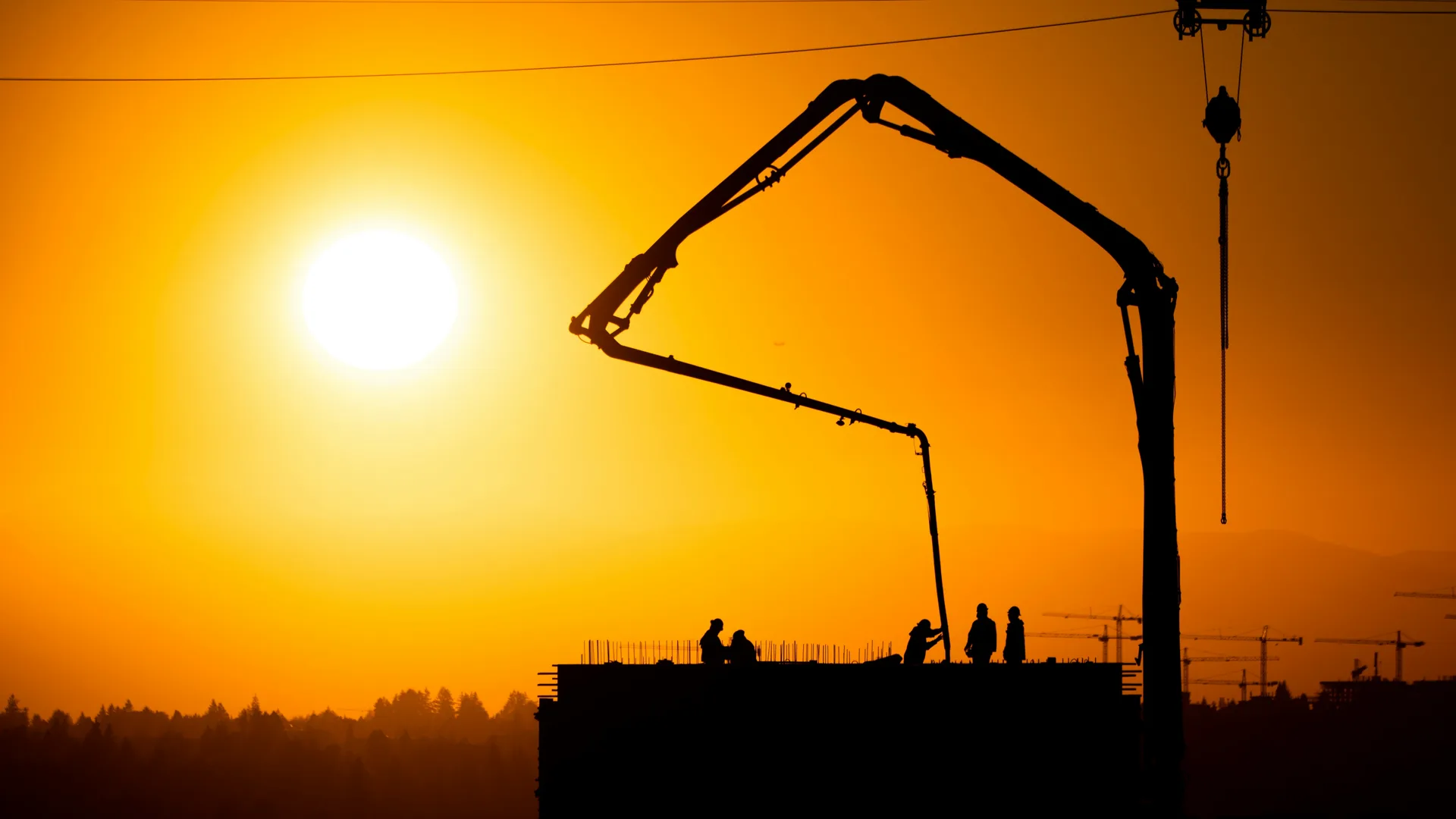 concrete boom pump on a Detroit construction site at sunset