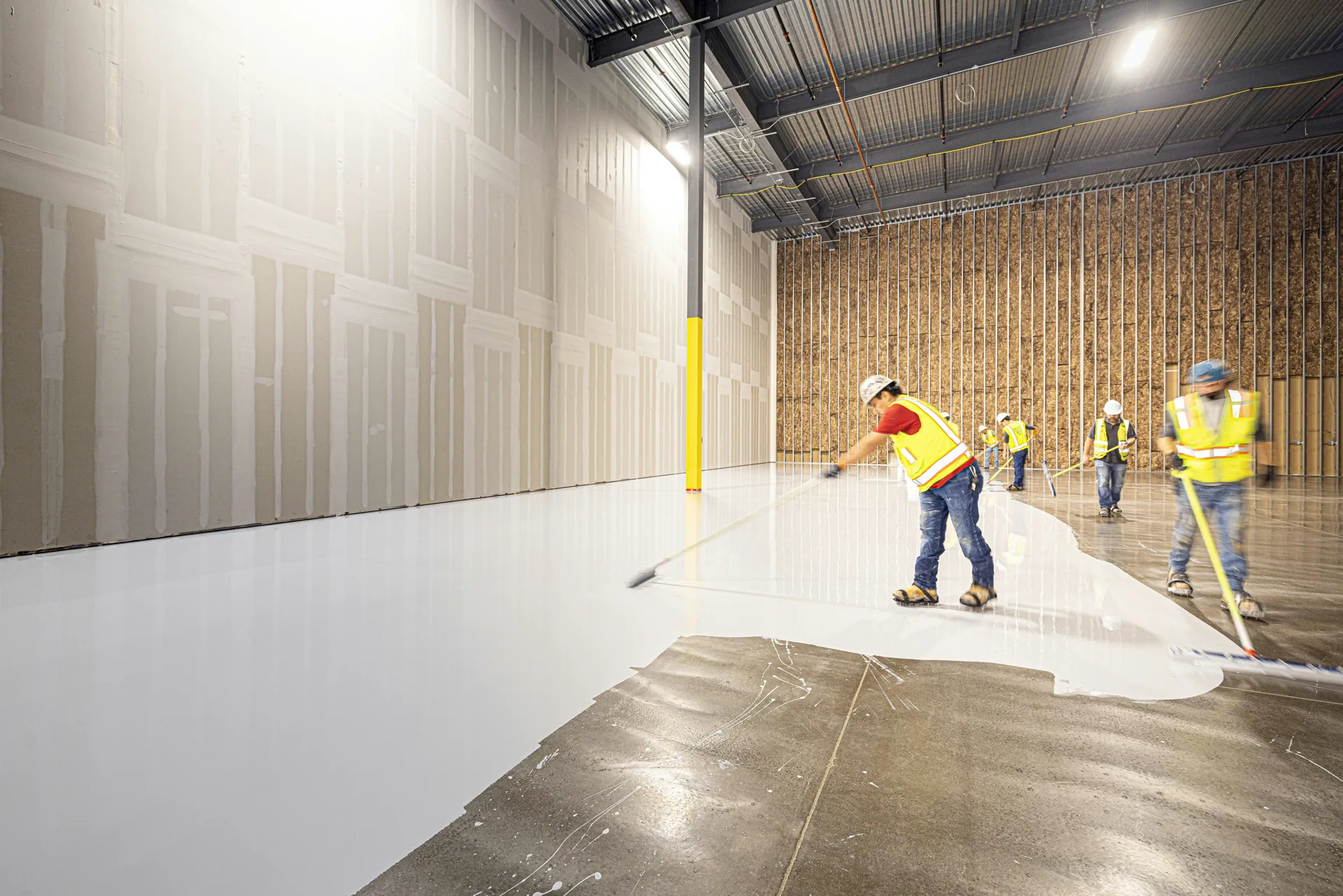Rust-Oleum coating crew squeegeeing a base coat in Detroit
