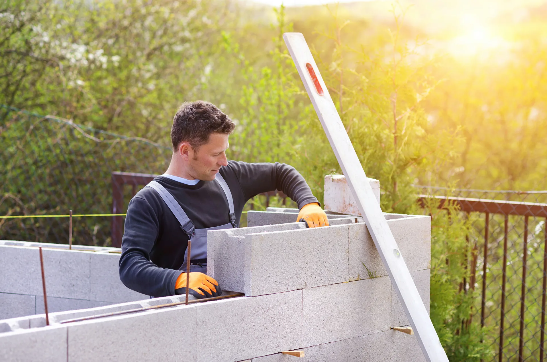 mason levelling a block retaining wall at a Detroit property