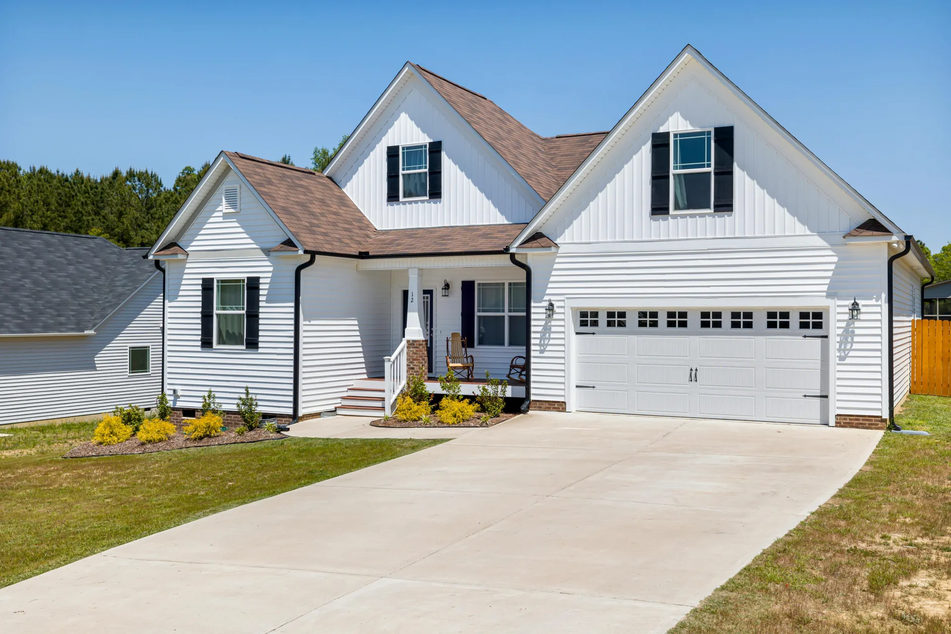 long concrete driveway at a Warren acreage home with double garage