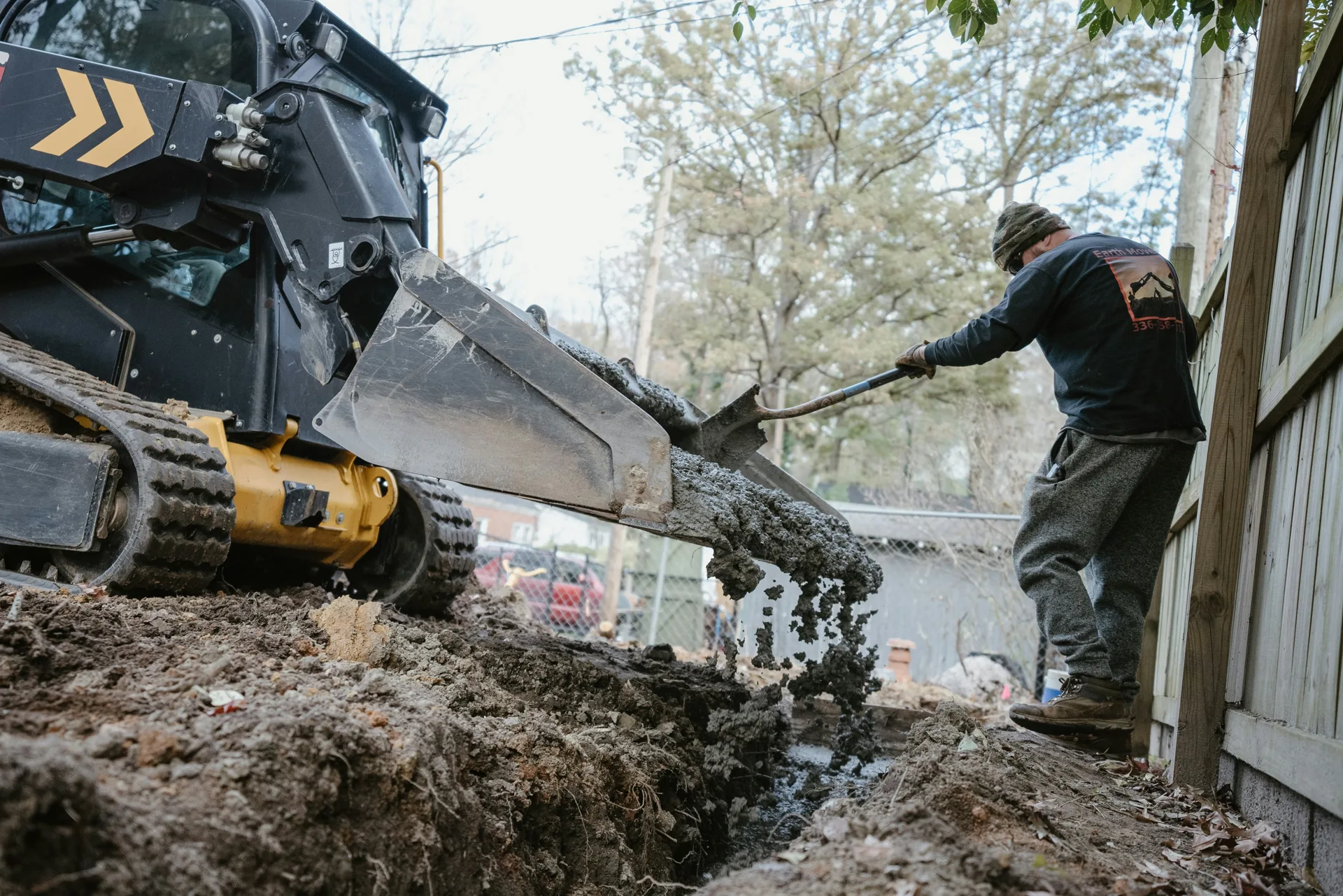 concrete foundation footing pour with a skid steer at a Detroit site