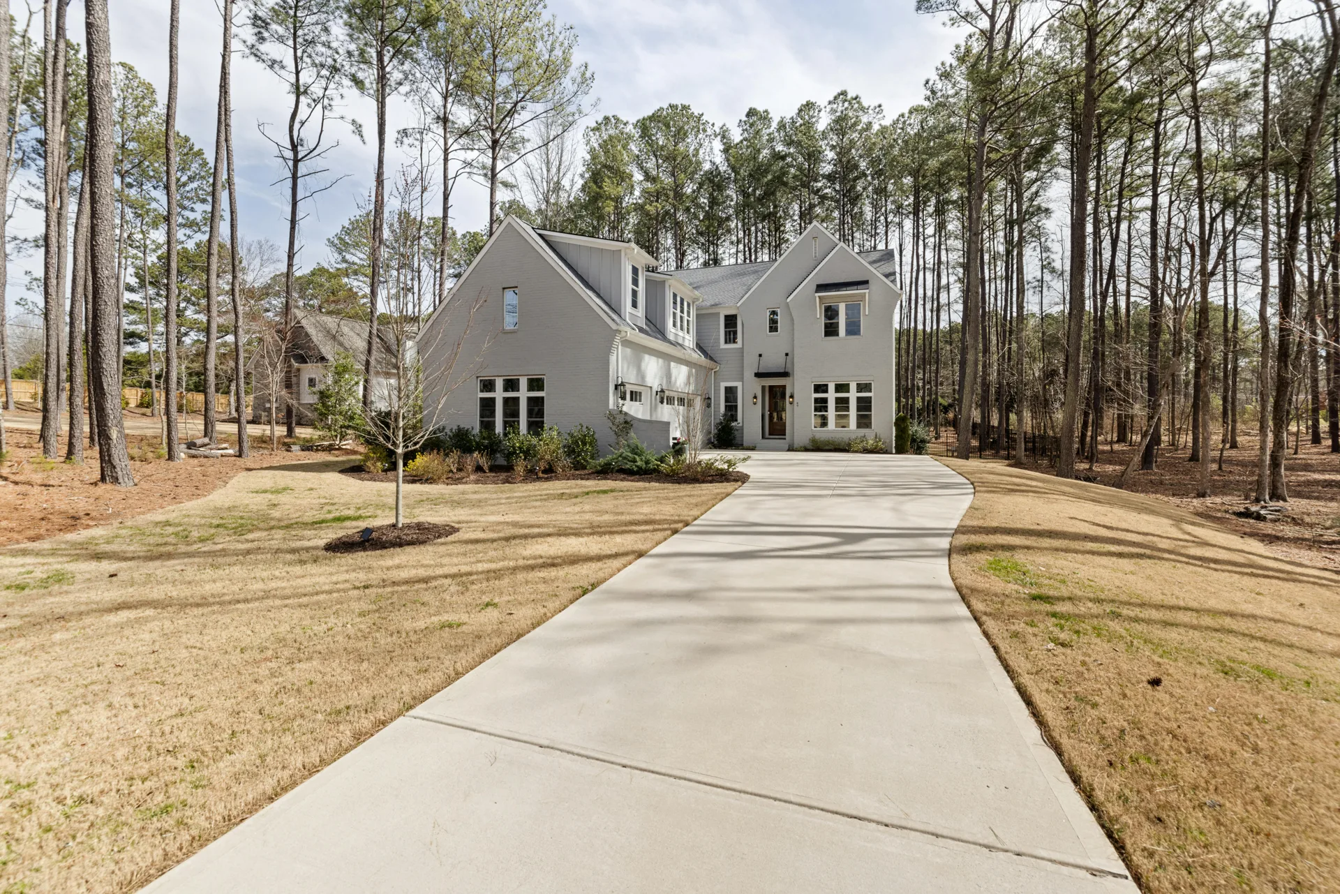 long curving concrete driveway through pines near Dearborn