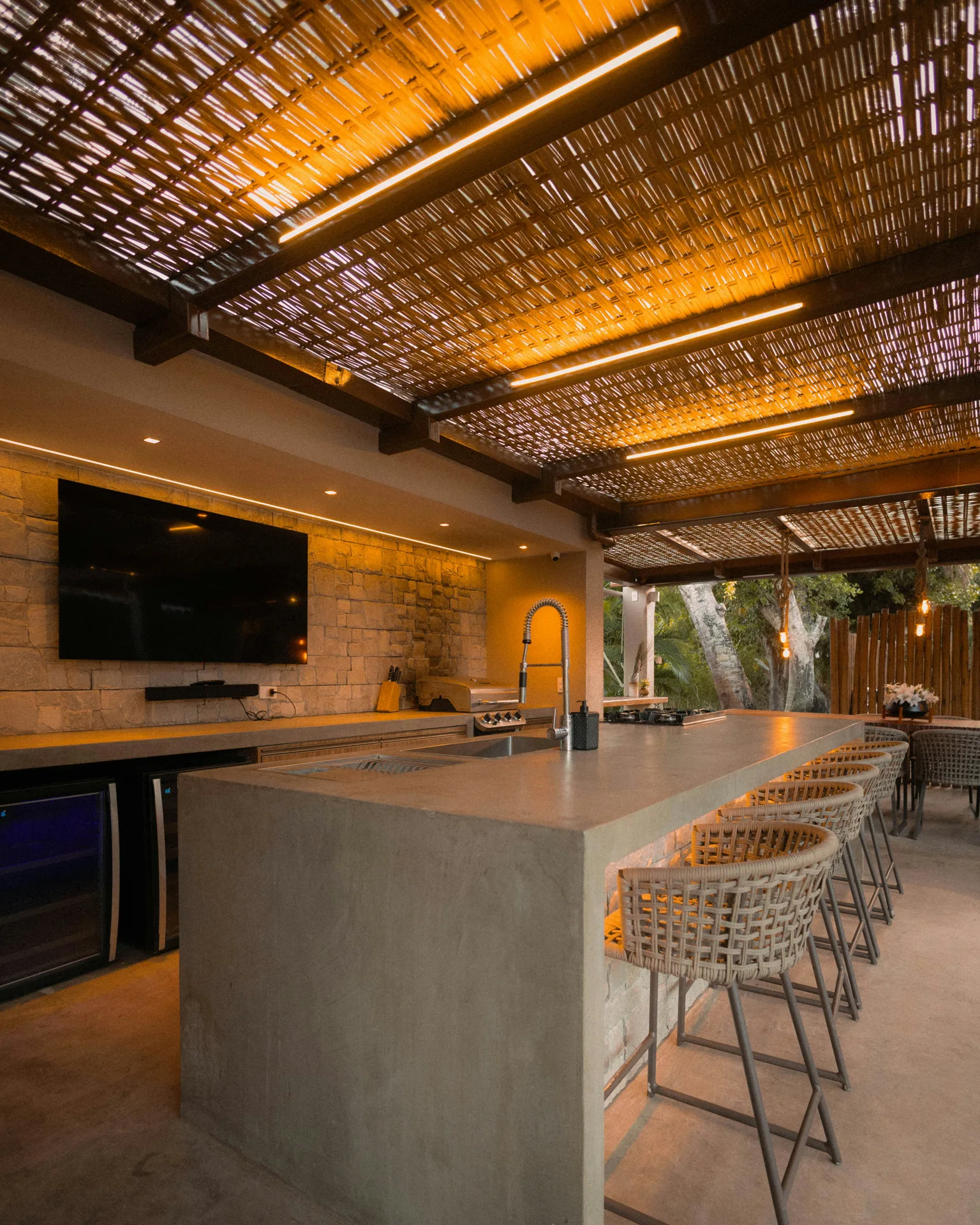 concrete outdoor kitchen bar under a pergola at a Detroit home